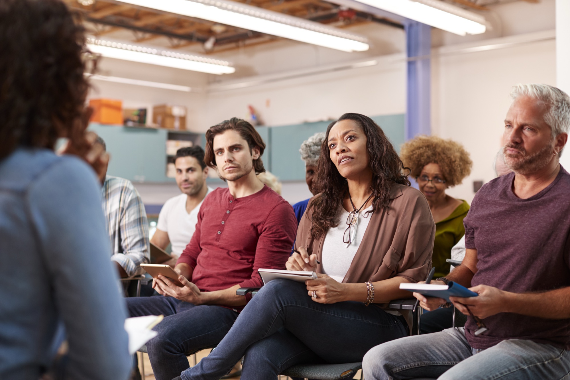Personas tomando notas durante una reunión comunitaria